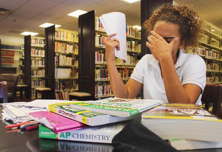 Student drowning in the ap books and study guides for the approaching exams.