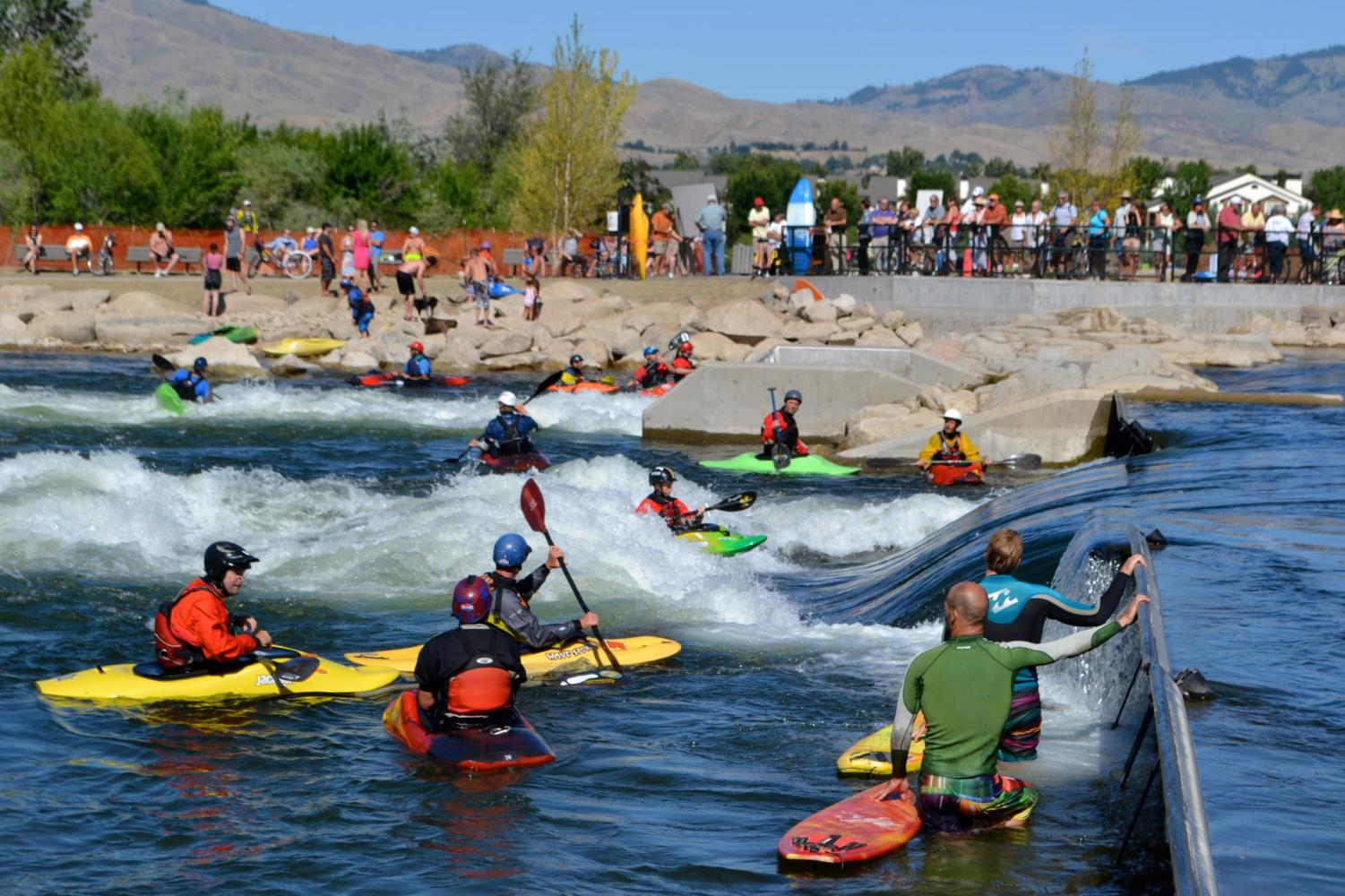 Boisians gather around the whitewater park and watch as kayakers take on the waves.