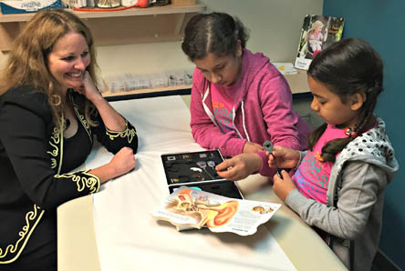 
Photo caption: The Mousavi girls work with a doctor, examining a diagram of the ear, after receiving their implants. 
Photo cred: St Luke’s 
