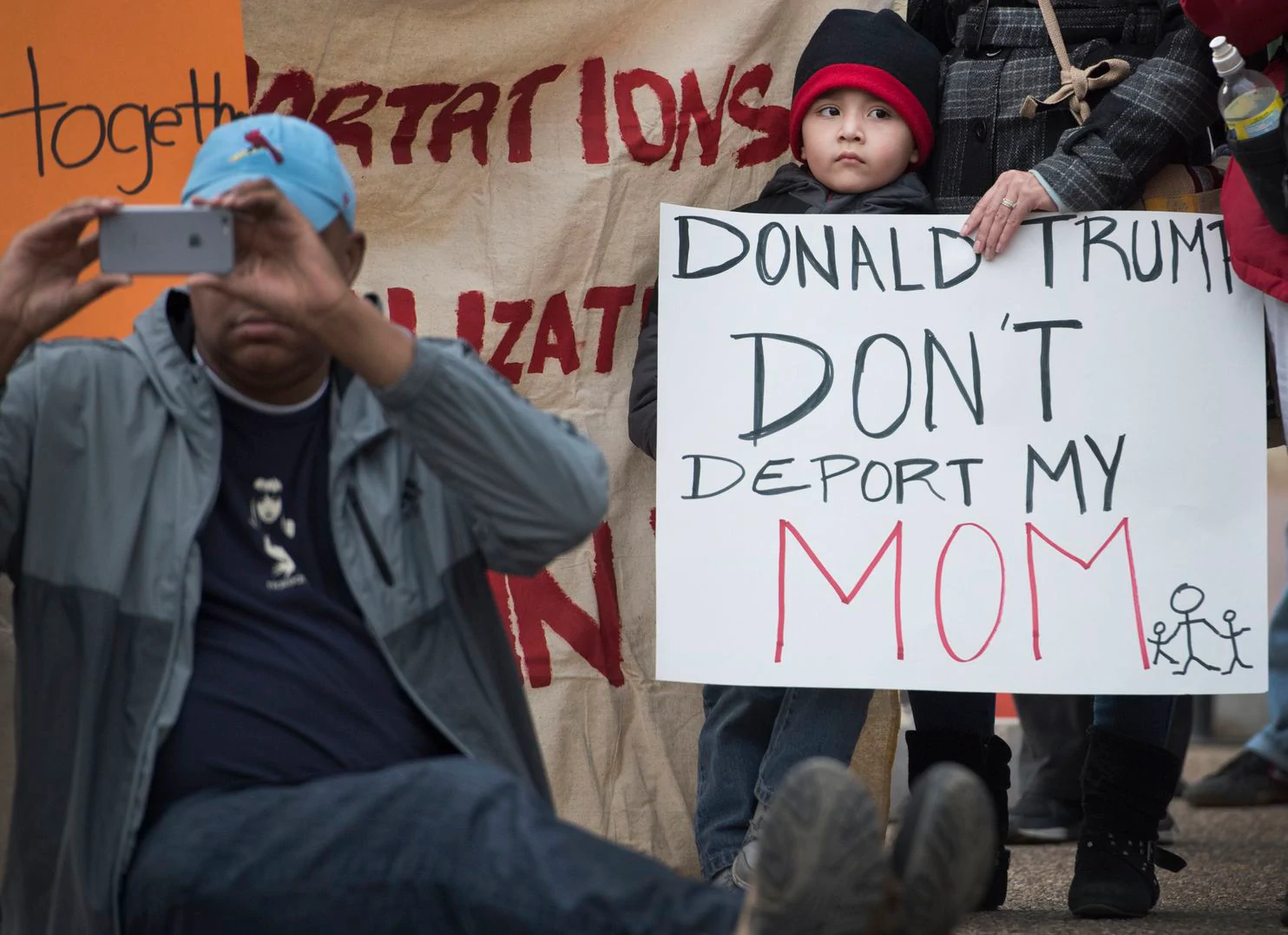 A child and his mother have a simple plea as they attend a rally together. 