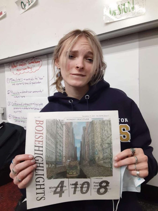Dina Hughes, a reporter, posing with November's issue of the Boise Highlights. 