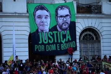 A sign calling for justice in the deaths of Indigenous expert Bruno Pereira and British journalist Dom Phillips hangs above a rally during the 2022 Brazilian presidential race (Silvia Izquierdo/AP Photo)